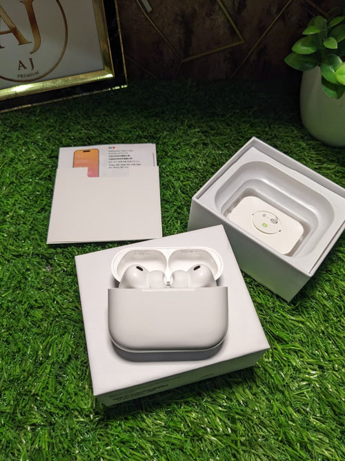 Wireless earbuds in a white case on grass with a blurred background