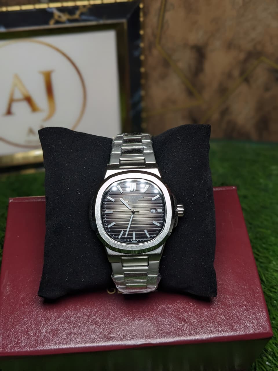 Silver watch on a black cushion with a blurred background