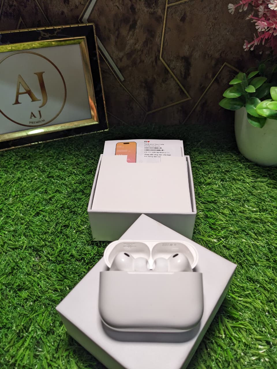 Wireless earbuds Apple pro 3 in a charging case on grass with a decorative background with AJ premium frame