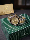 Luxury watch with gold and silver accents on a green Rolex box.
